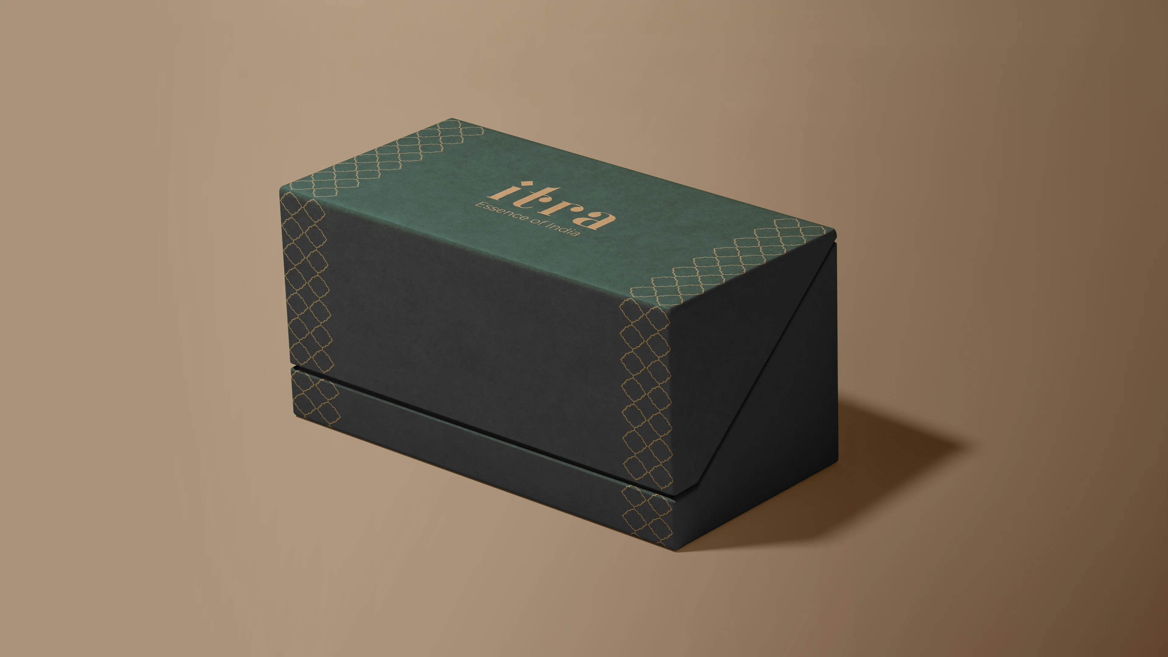 Single Itra gift box with dark charcoal base and forest green lid, gold lattice pattern at each corner and gold wordmark centered on the lid